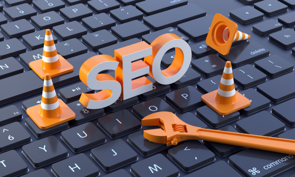 3D text 'SEO' with orange traffic cones and wrench placed on a computer keyboard, symbolizing website optimization and technical SEO work